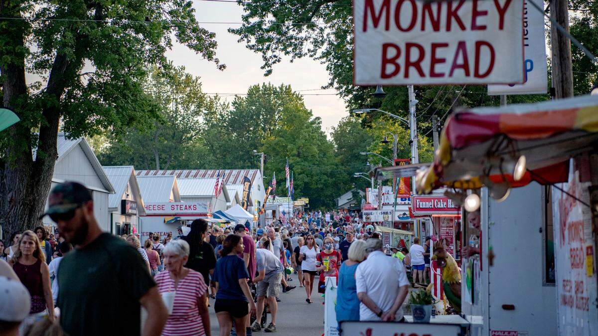 Fairgoers walk along the Rhone Avenue at the Centre County Grange Fair on Thursday, Aug. 26, 2021.