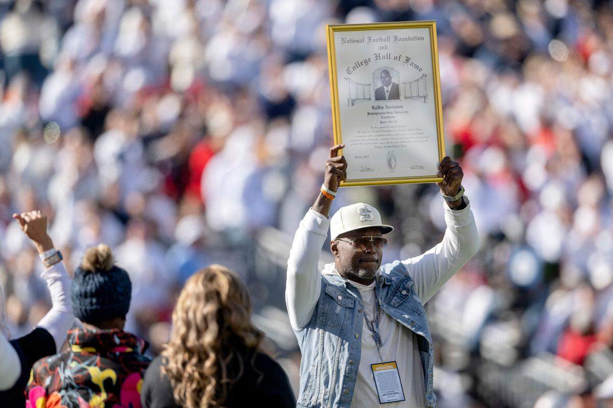 LaVar Arrington holds up a plaque for being in the National Football Foundation College Hall of Fame during the football game on Saturday, Oct. 29, 2022.