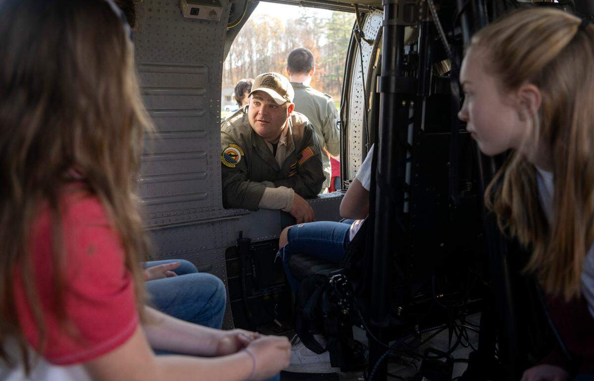 Marcus Burke from the Navy VX-1 talks to Bald Eagle Area students as they sit in the helicopter that was flown to the Veterans Day celebration on Thursday, Nov. 9, 2023.