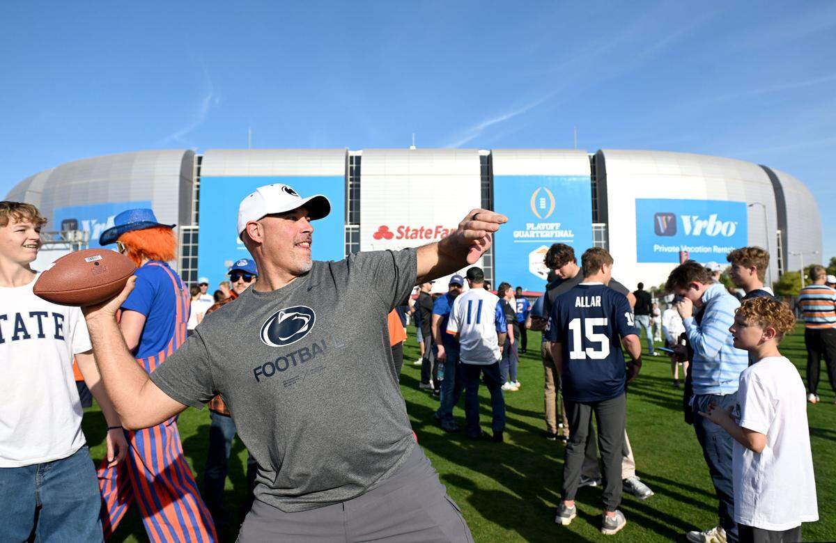 Tim Detish throws a football as he hangs outside of State Farm Stadium before the Fiesta Bowl on Tuesday, Dec. 31, 2024.