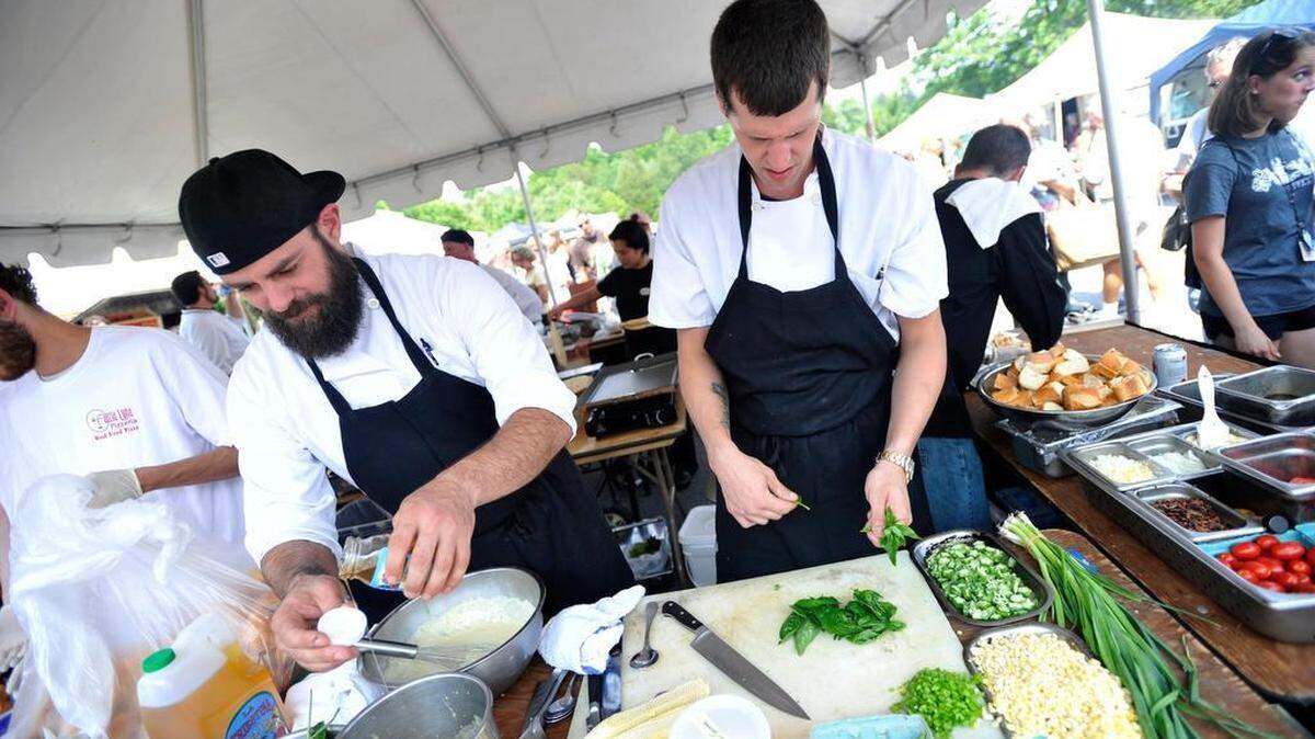 Jonathan Forshey, left, and Andrew Hufnagel, of the Gamble Mill restaurant, prepare a dish during the Golden Basket competition at the Boalsburg Farmers Market in 2014.
