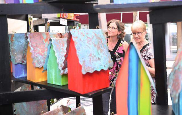 Laurie Verost, left, and Cathie Verost, of Philipsburg, look at birdhouses at Fly Home Birdhouses at the 57th Central Pennsylvania Festival of the Arts.
