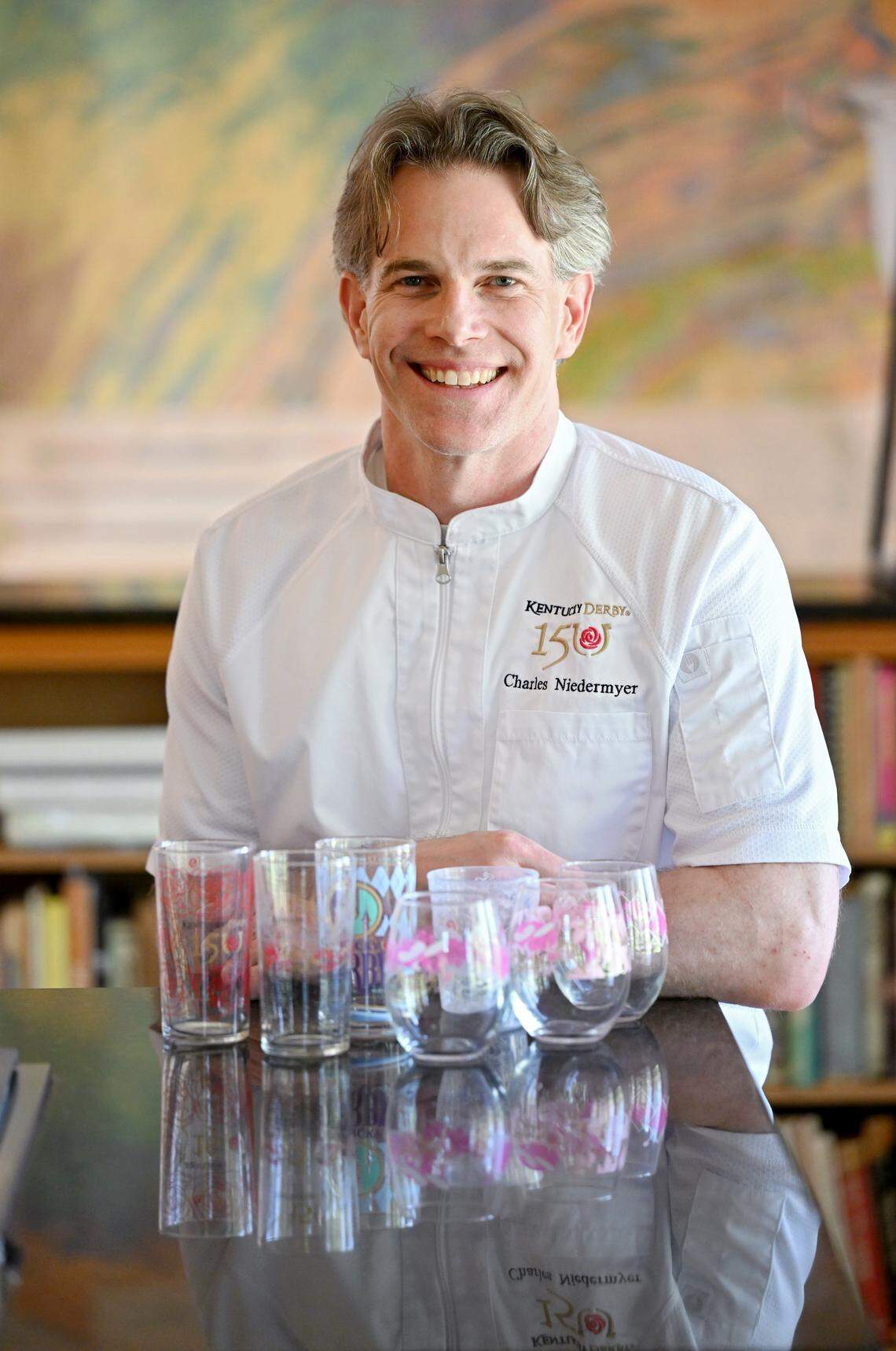Chef Charles Niedermyer poses with glasses from previous Kentucky Derby races. 