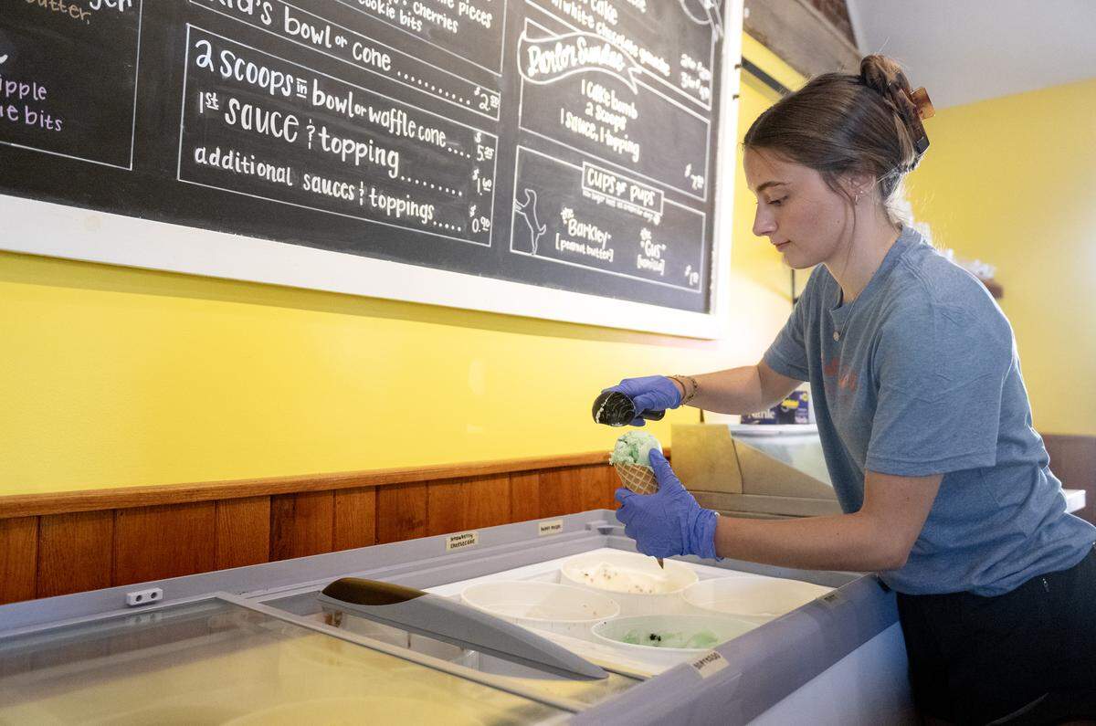 Lorna Dixon scoops a waffle cone of the double thin mint ice cream at The Parlor in Bellefonte on Thursday, Aug. 14, 2025.  