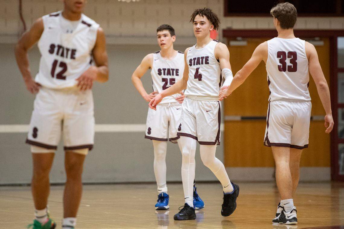 State College’s Braeden Shrewsberry high-fives his teammates after surpassing the 1,000-point mark during a PIAA basketball game between State High and Chambersburg at the State High gym on Tuesday.