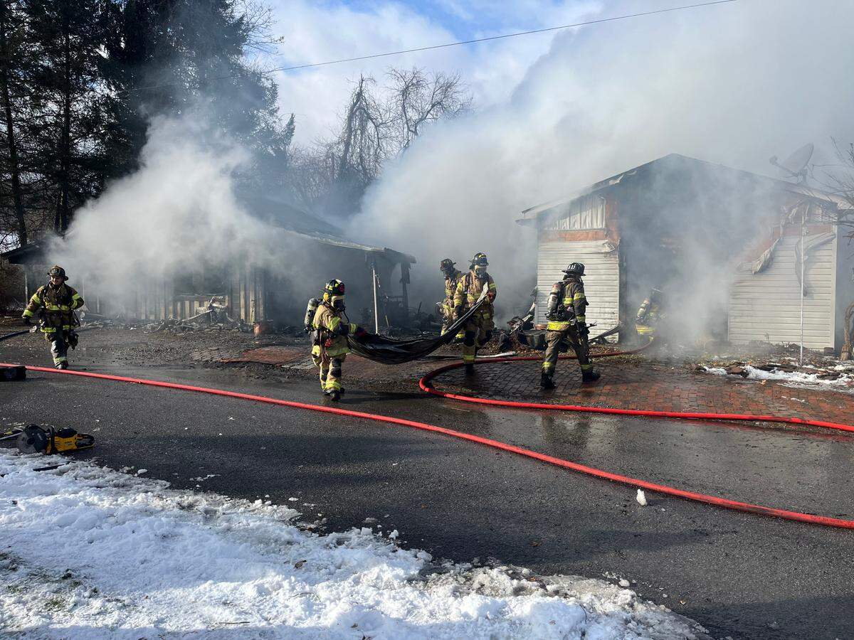 Firefighters work on the scene Thursday afternoon of a fire in the 300 block of Apple Street in Julian.