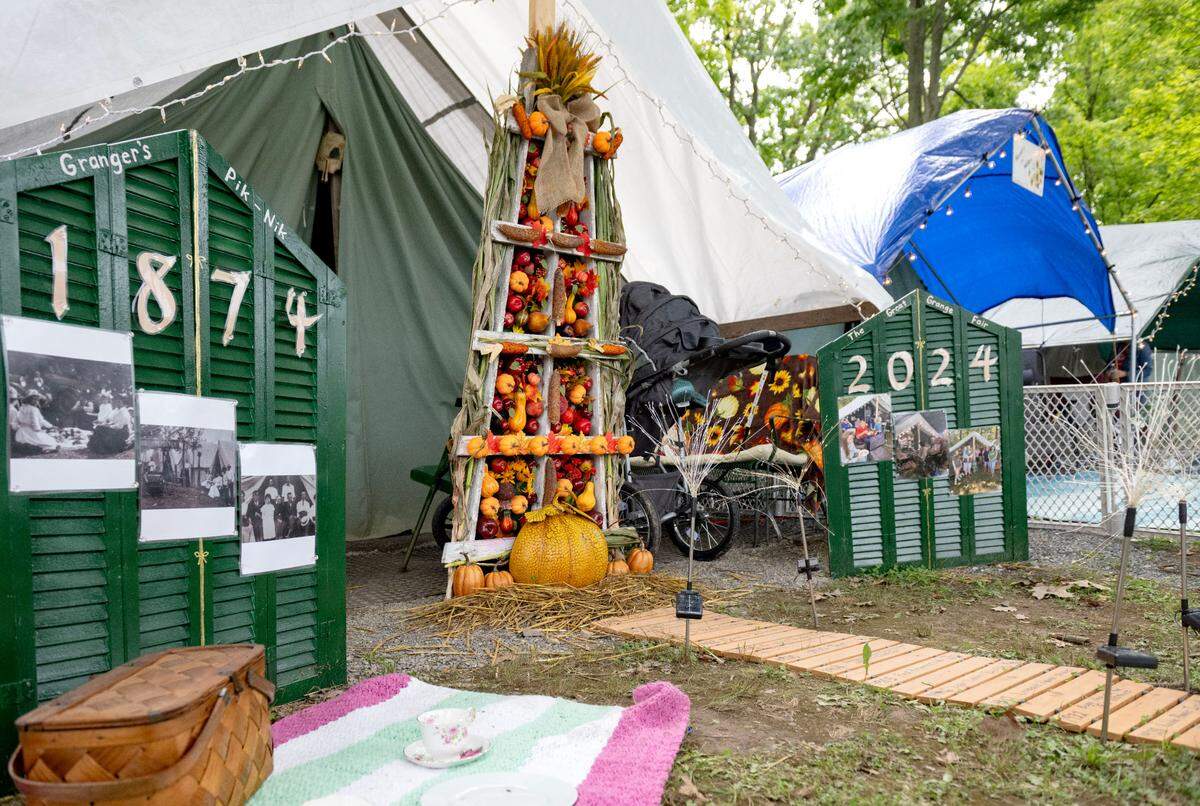 Sandy Mansfield decorated her family tent to honor the 150th anniversary of the Grange Fair with a timeline, a harvest monument, photos, and in the evening a video featuring fireworks.