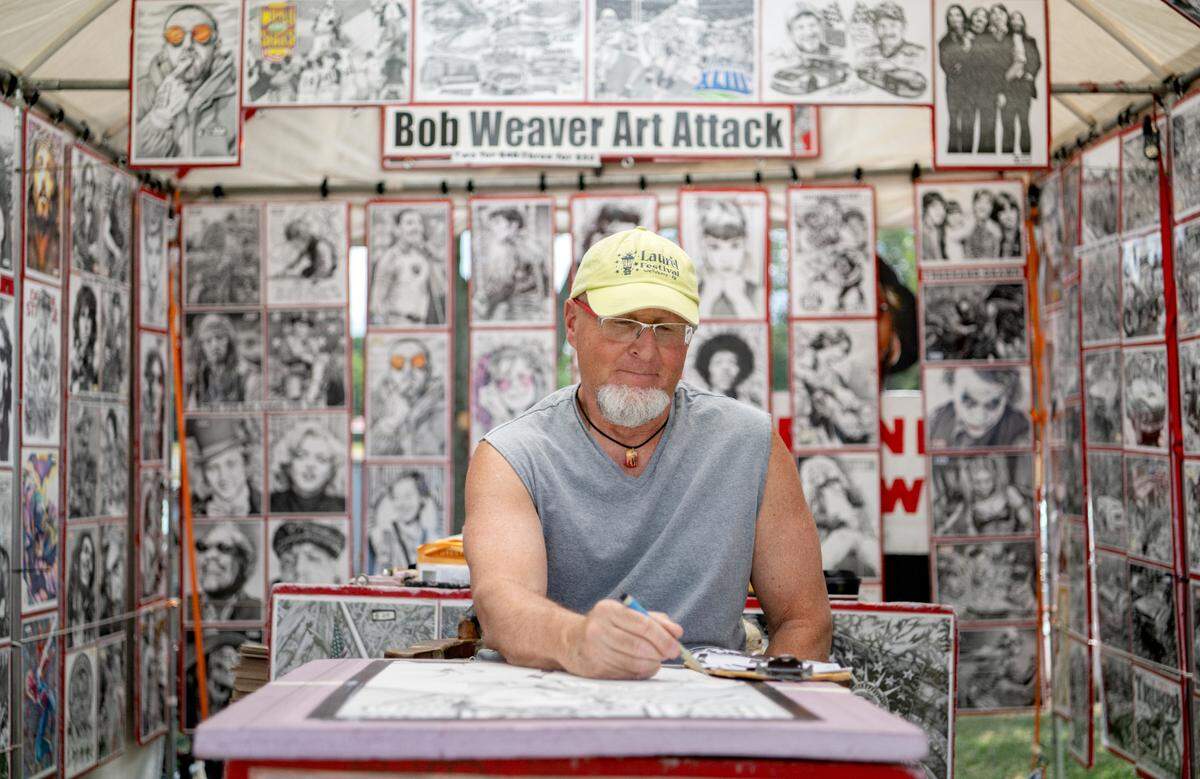 Bob Weaver works on a pen drawing of Elvis in his booth at the People’s Choice Festival of Pennsylvania Arts & Crafts on Friday, July 15, 2022.