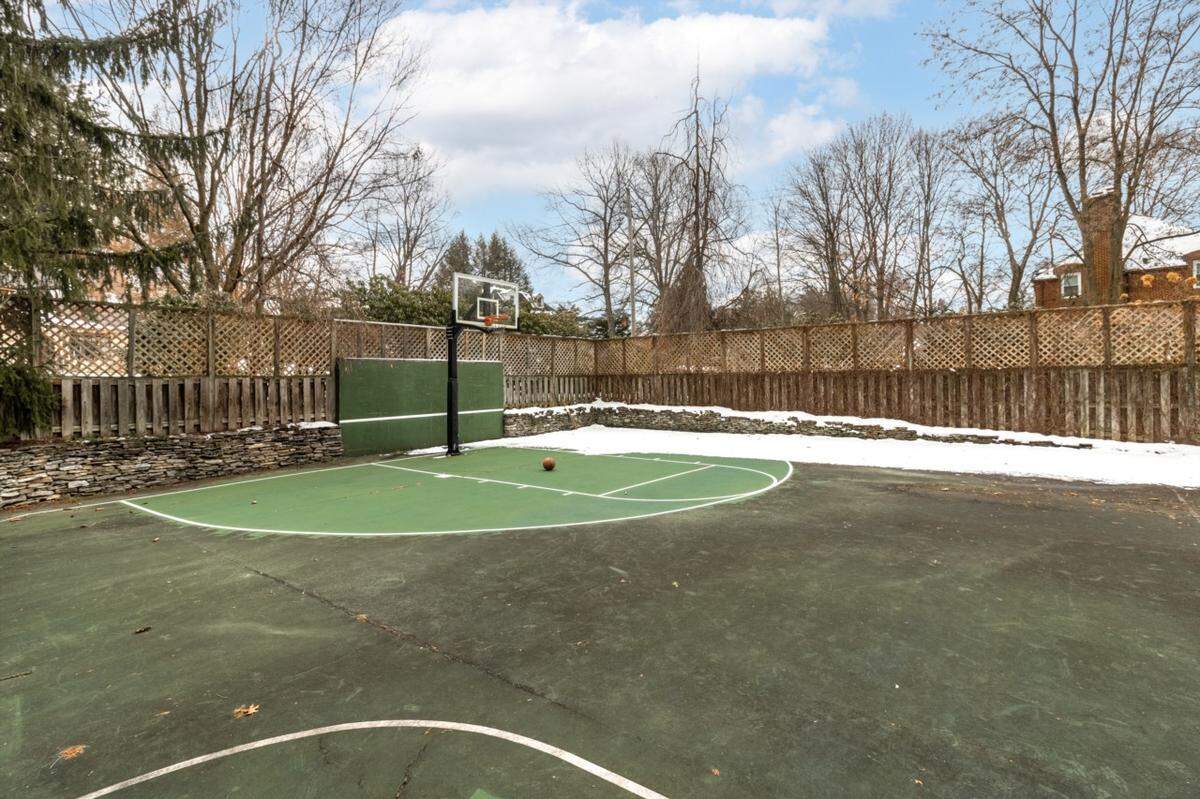 The backyard of this home has a basketball court that can double as pickle ball and tennis courts. It’s located near Penn State.