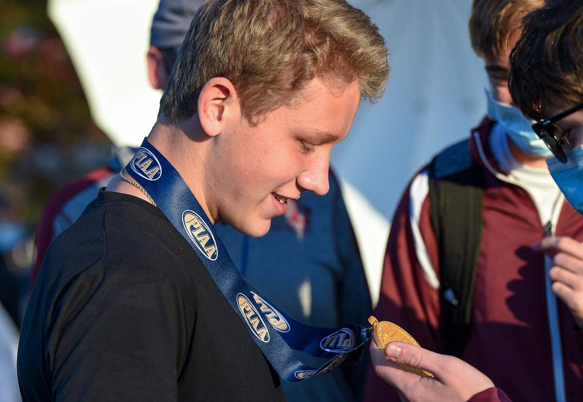 State College’s Brady Bigger wins the boys Class AAA race in 16:07, and shows off his gold medal to teammates, at the PIAA Cross Country Championships on Saturday, November 7, 2020 in Hershey. (Jeremy Drey — For the Centre Daily Times)