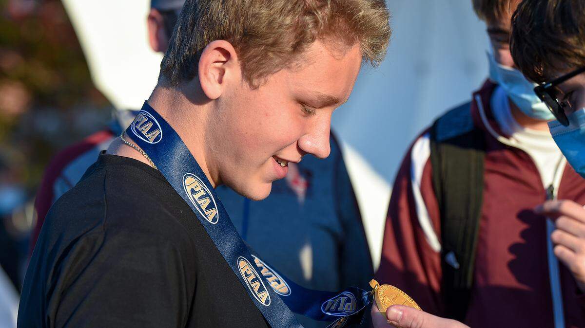 State College’s Brady Bigger wins the boys Class AAA race in 16:07, and shows off his gold medal to teammates, at the PIAA Cross Country Championships on Saturday, November 7, 2020 in Hershey.