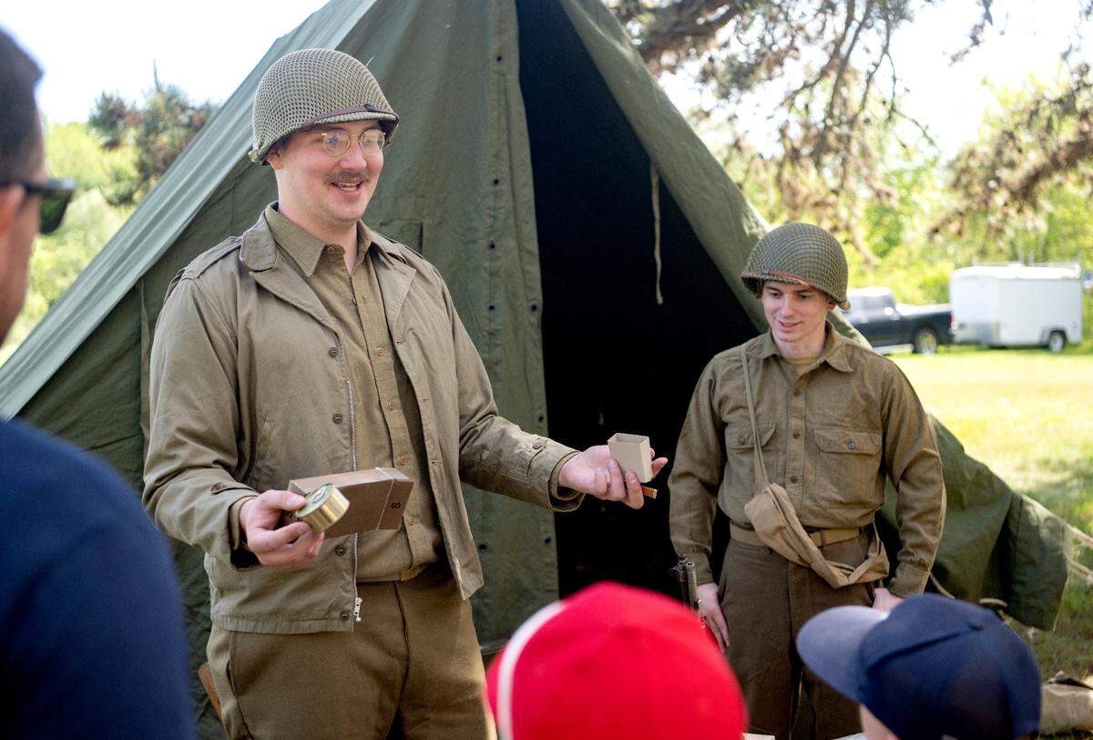 Kyle Marsh represents the 28th Infantry Division as he shows visitors what soldiers would get in their supper box during a World War II encampment at the Pennsylvania Military Museum on Saturday, May 27, 2023.