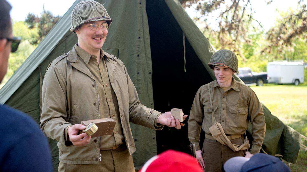 Kyle Marsh represents the 28th Infantry Division as he shows visitors what soldiers would get in their supper box during a World War II encampment at the Pennsylvania Military Museum on Saturday, May 27, 2023.