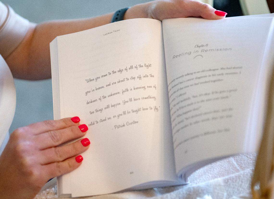 LeeAnn Tripp flips through her book “Finding the Rainbow,” which features inspirational quotes between chapters.