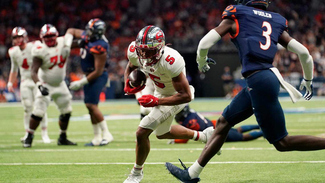 Western Kentucky wide receiver Mitchell Tinsley (5) runs past UTSA cornerback Tariq Woolen (3) for a touchdown after making a catch during the Conference USA championship Friday, Dec. 3, 2021, in San Antonio.
