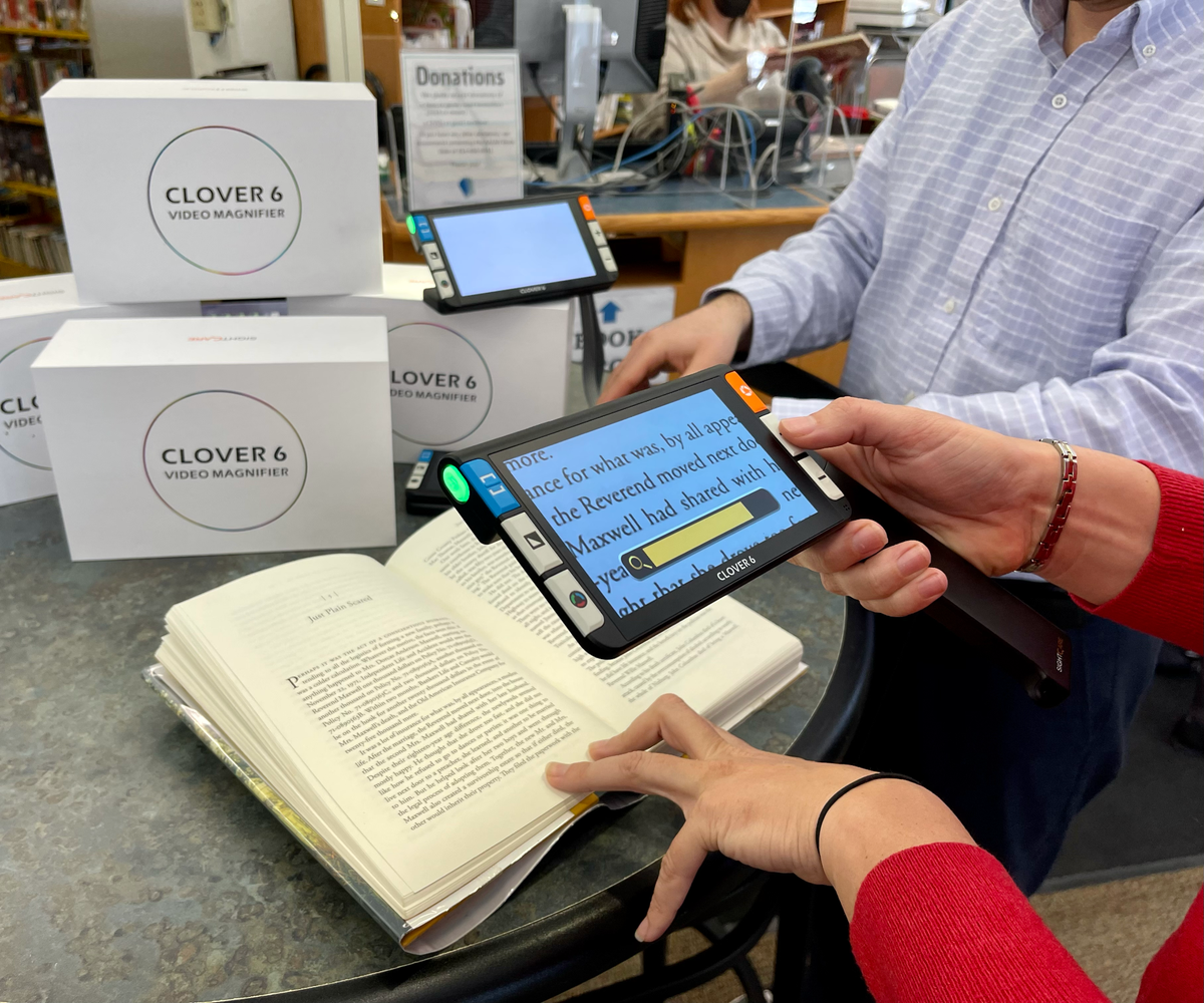 Lindsey Kurtz, chair of the Centre County Library board, learns how to use the handheld digital magnifier, which was part of a donation to the library from North Central Sight Services on Monday, Feb. 28, 2022.