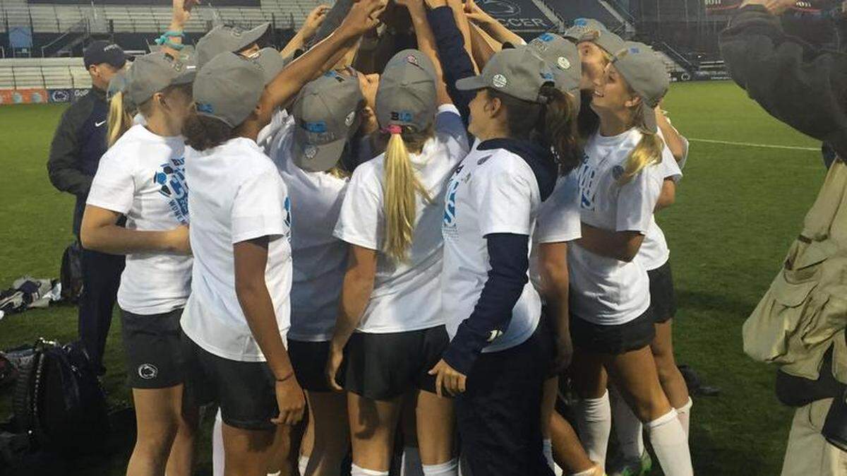 The Penn State women’s soccer team celebrates with the trophy for winning the Big Ten regular-season title after beating Illinois on Sunday in the conference quarterfinals.
