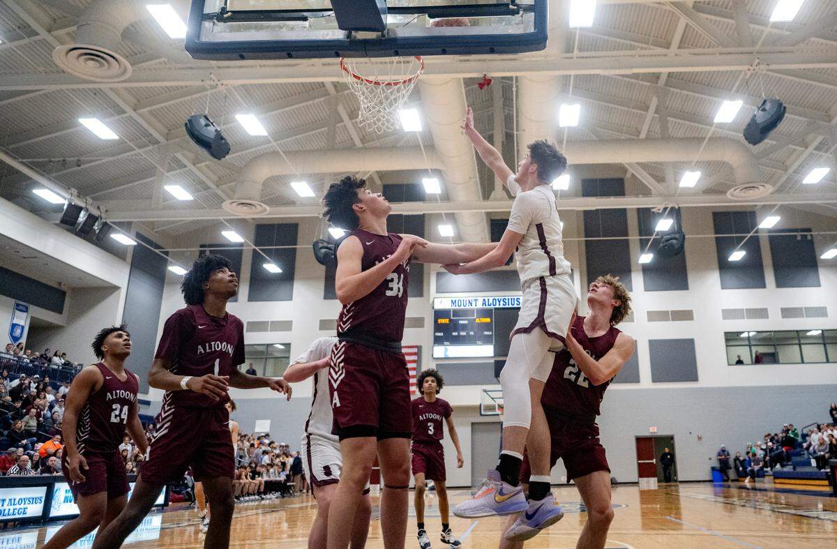 State College’s Ryan Perks makes a basket around Altoona defenders during the District 6 6A championship game at Mount Aloysius College on Friday, Feb. 24, 2023.