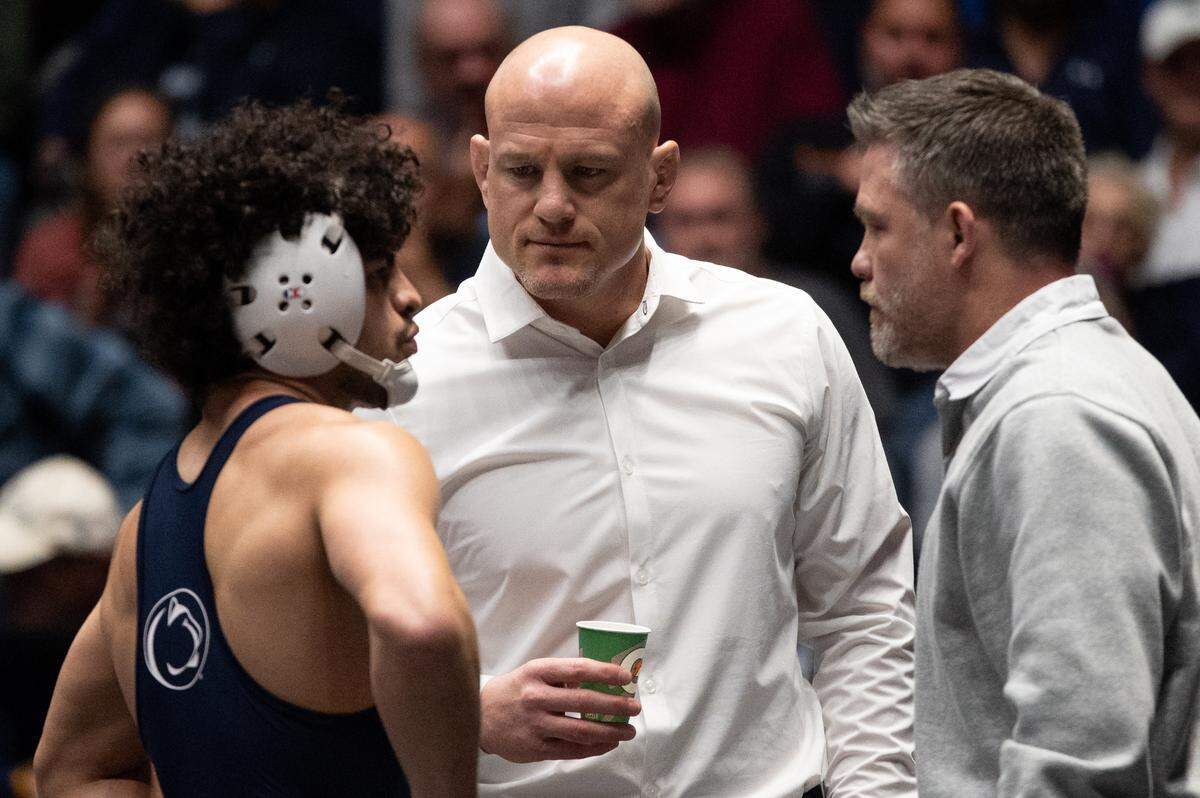 Penn State head coach Cael Sanderson, middle, speaks with Beau Bartlett, left, during the NWCA All-Star Classic at Rec Hall on Saturday, Nov. 16, 2024.