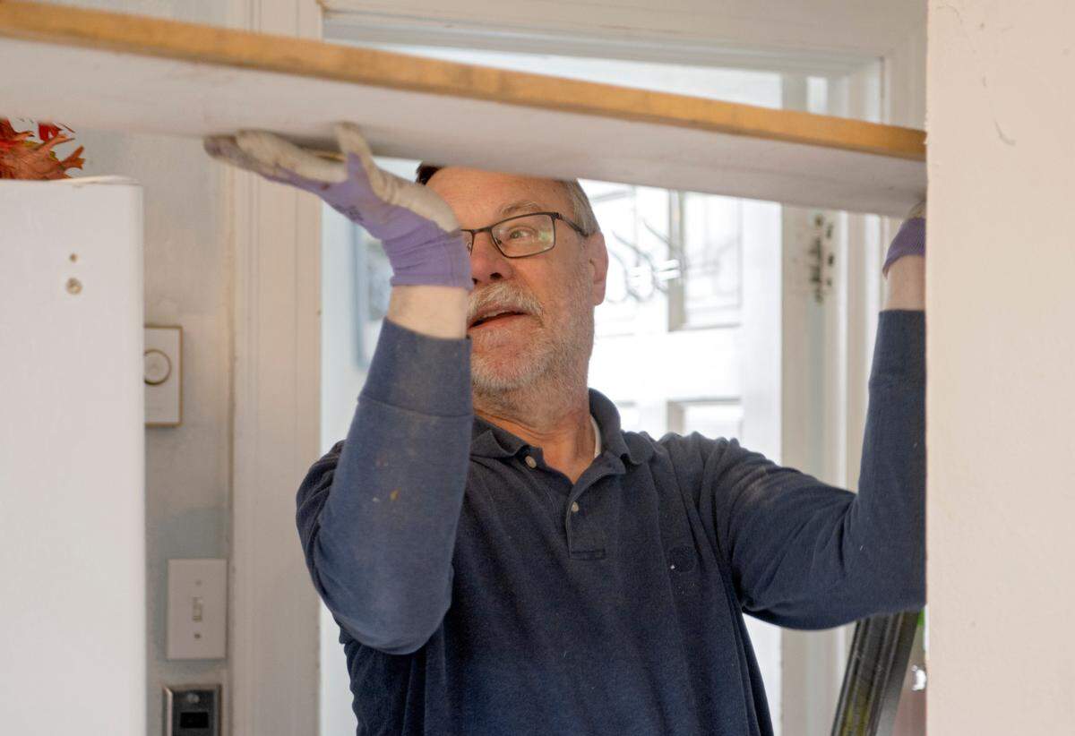 Jay Aubuchon, a volunteer with Out of the Cold, pulls wood out of a storage space to be used as renovations are underway on Wednesday, March 5, 2023.