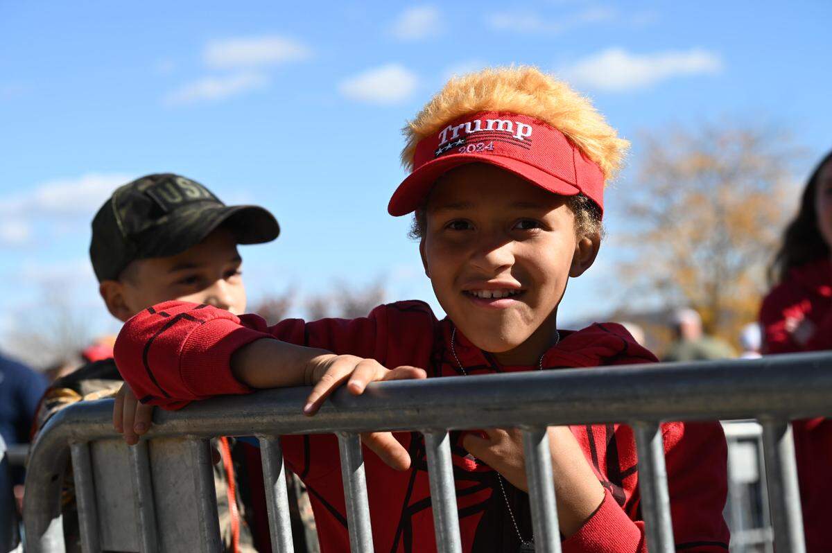 Eli Covaleski smiles as he waits in line to enter the Bryce Jordan Center for a Trump rally on Saturday, Oct. 26, 2024.