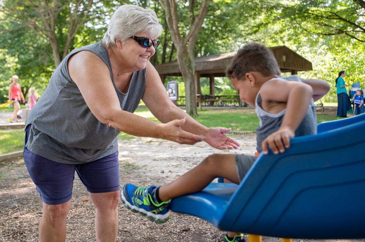 Amy Mitchell reaches her arms out to catch her grandson as he comes down the slide at Spring Creek Park in August 2018. Mitchell has guardianship of her 3-year-old grandson.