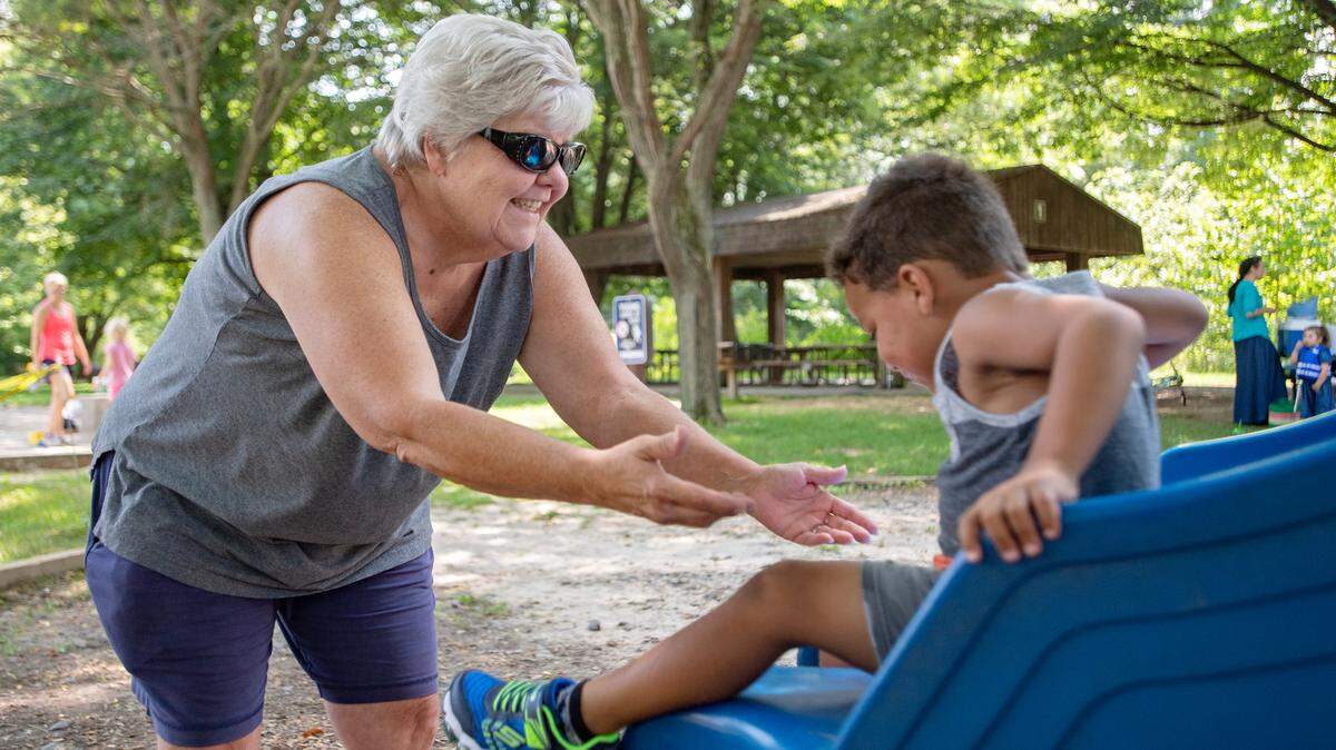 Amy Mitchell reaches her arms out to catch her grandson as he comes down the slide at Spring Creek Park in August 2018.