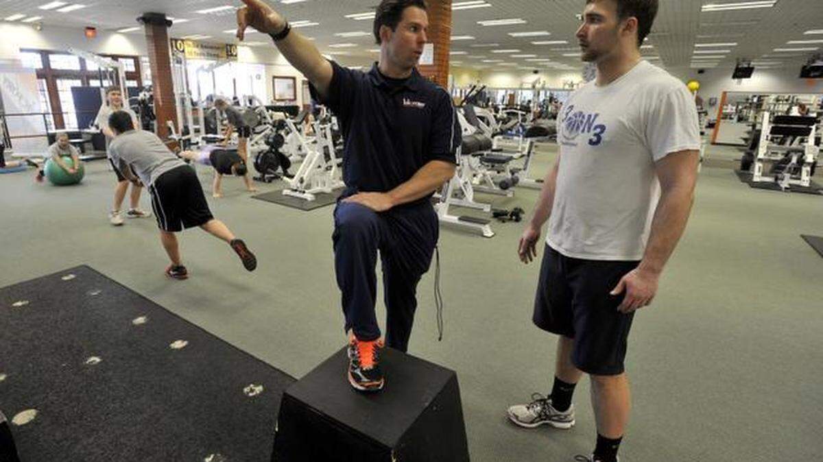 Rob Oshinskie, owner of Victory Sports and Fitness, works with Lonni Koudela, 17, of State College, at the gym in the South Hills Plaza.
