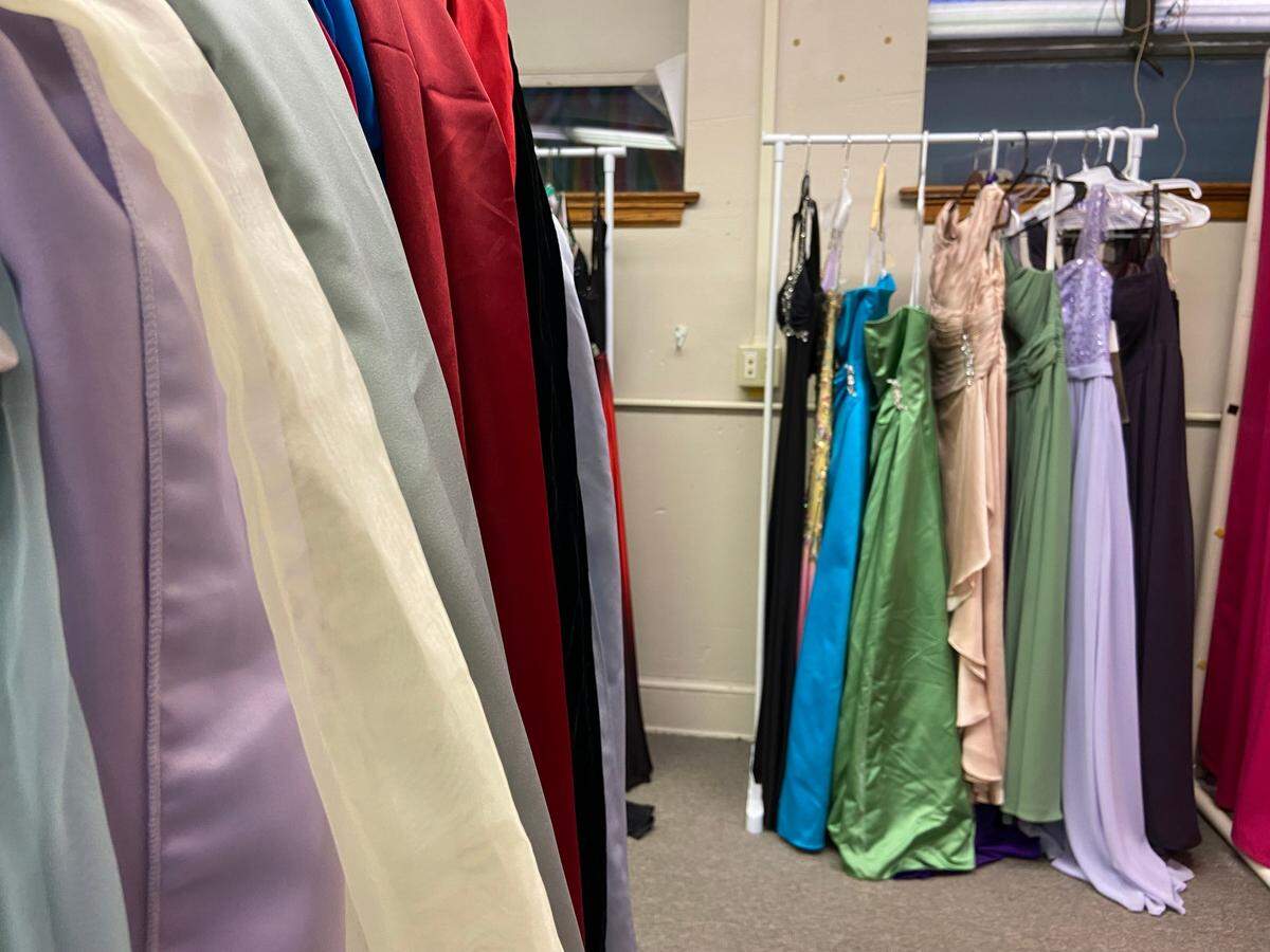 A rack of silk scarves, belts and shawls sits near a dressing rack of prom dresses at the Fairmount Building, which will host the Prom Attire Event next month.