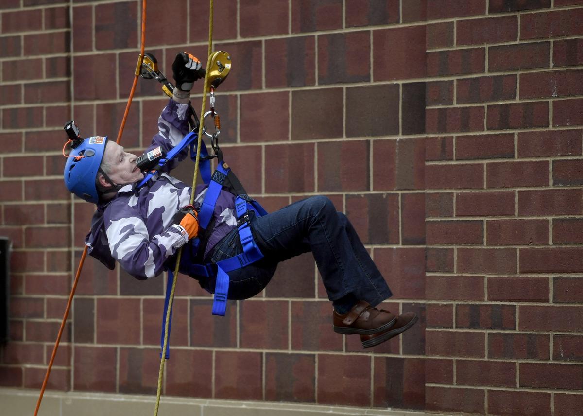 Marie Cameron lowers herself to the ground from the roof of the Fraser Centre on Thursday during the State College Over the Edge event.