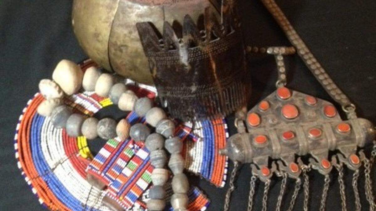 Ancient clay beads, Chad (West Africa), a shell/hair ornament from Sumba (Oceana) on a beaded Maasai (East Africa) necklace next to large silver and coral women’s necklace from Turkistan and a men’s Dinka headdress (North East Africa) are part of the “Art of Adornment” display at the Bellefonte Art Museum for Centre County.
