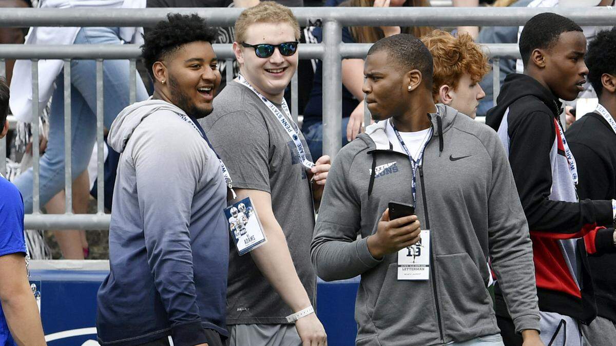 Penn State recruit RJ Adams laughs with friends from the sidelines as the team warms up for the Blue-White game on Saturday, April 13, 2019.