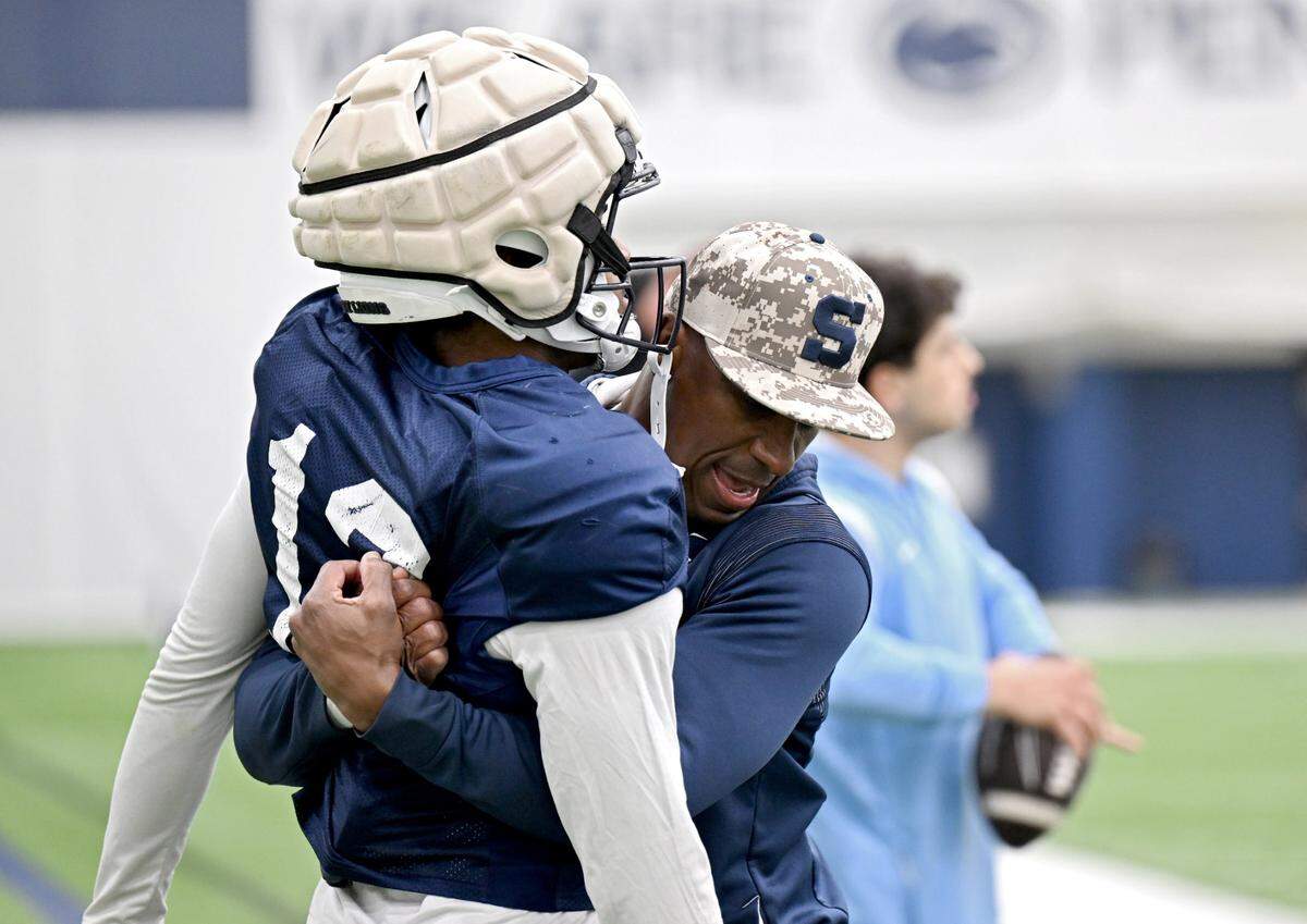 Penn State safeties coach Anthony Poindexter demonstrates a technique with cornerback Jon Mitchell during spring practice on Tuesday, April 8, 2025.