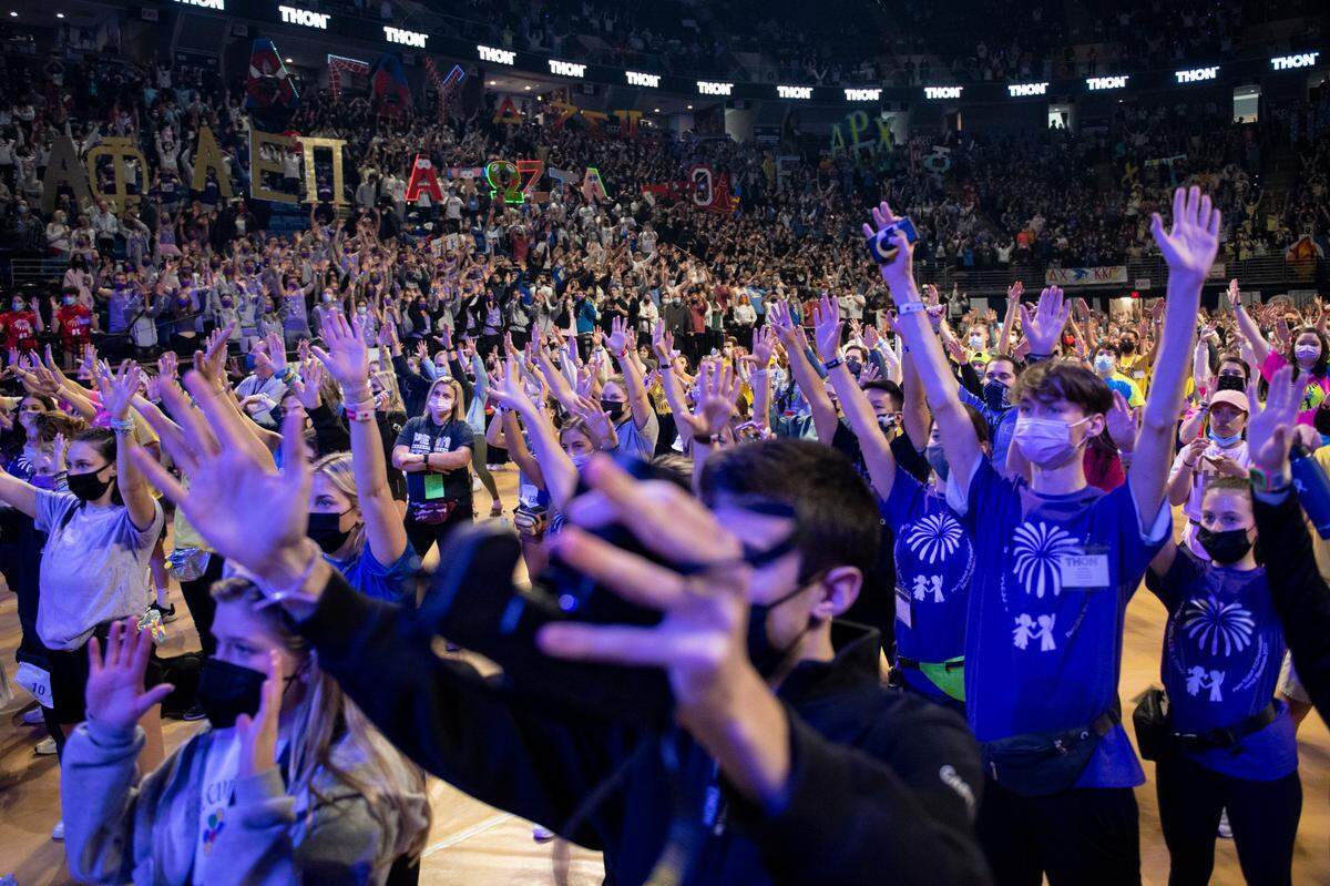 Thon participants raise their hands while performing the line dance during the Penn State IFC/Panhellenic Dance Marathon on Saturday.