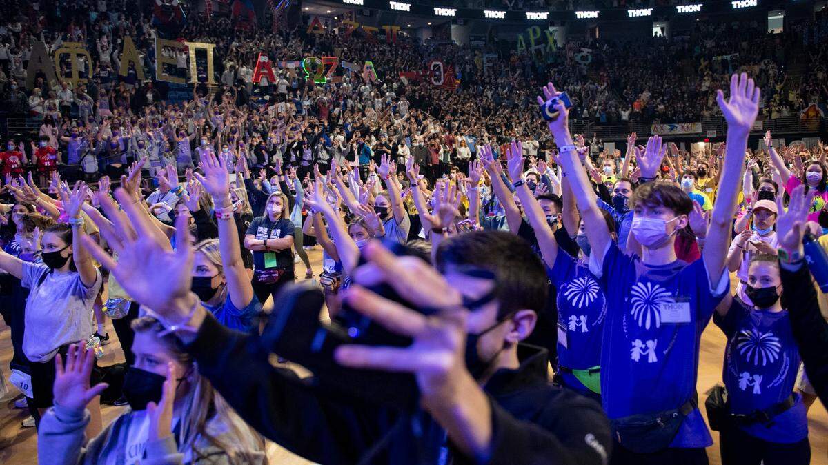 Thon participants raise their hands while performing the line dance during the Penn State IFC/Panhellenic Dance Marathon, Thon 2022 on Saturday, Feb. 19, 2022 in University Park, Pa.