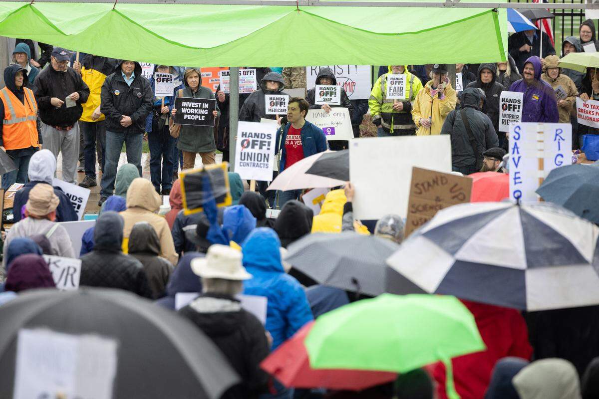Protesters hold signs and umbrellas Saturday while listening to speakers at the “Hands Off!” rally at State College’s Sidney Friedman Park, in opposition of President Donald Trump. The event was part of a nationwide effort that saw more than 1,000 similar rallies held across all 50 states.