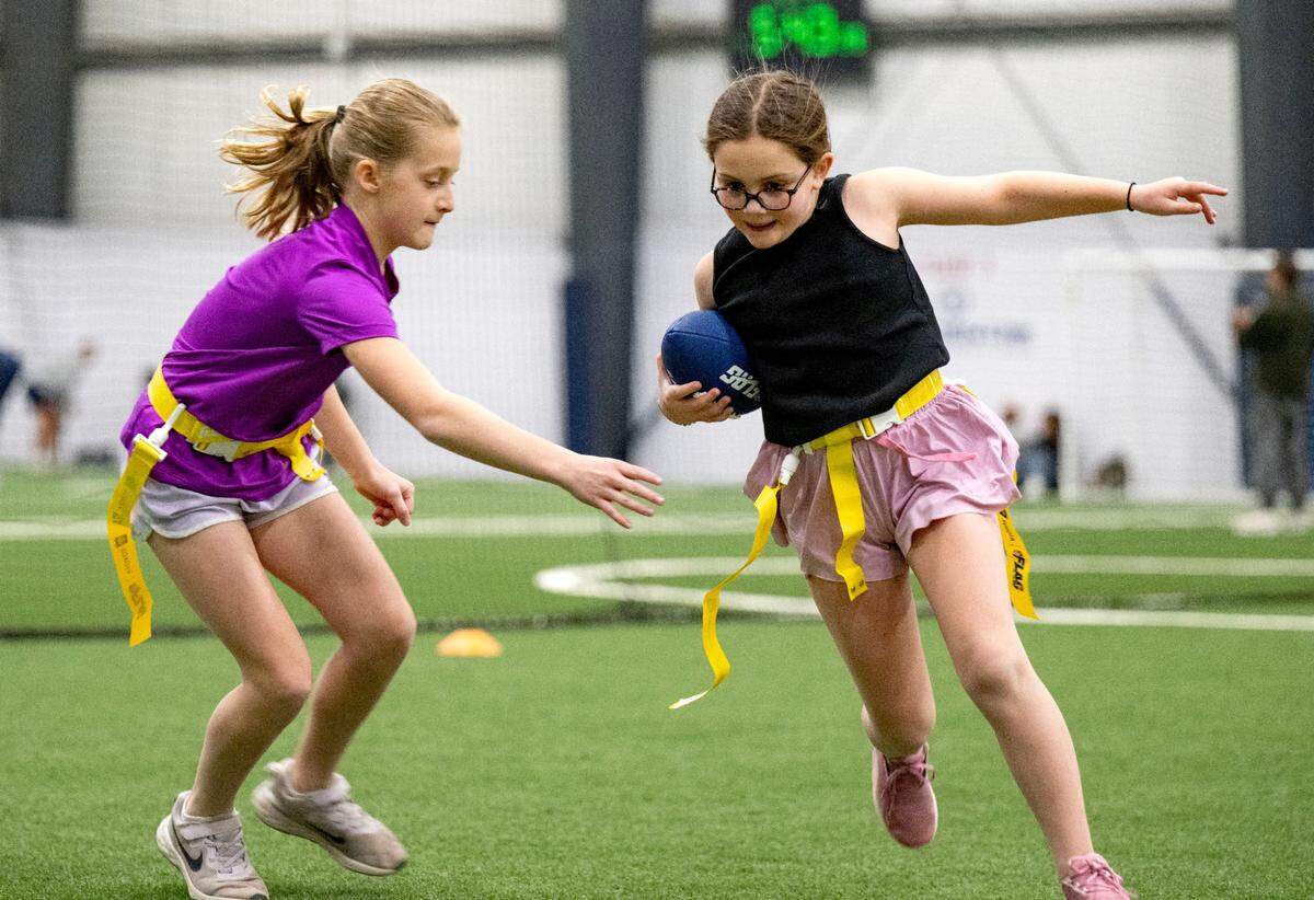Charley Schwartz cuts down the field with the ball from Abi Brennan during girls’ flag football practice at Nittany Valley Sports Centre on Wednesday, March 26, 2025.