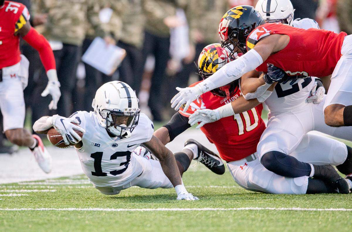 Penn State wide receiver KeAndre Lambert-Smith reaches for a few more yards as he is tripped up by Maryland defenders during the game on Saturday, Nov. 6, 2021.