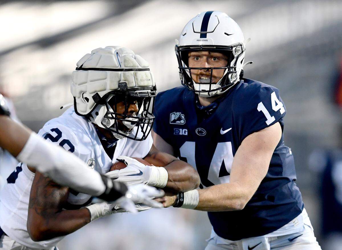 Penn State quarterback Sean Clifford hands off to running back Devyn Ford during practice on Friday, April 23, 2021 at Beaver Stadium.