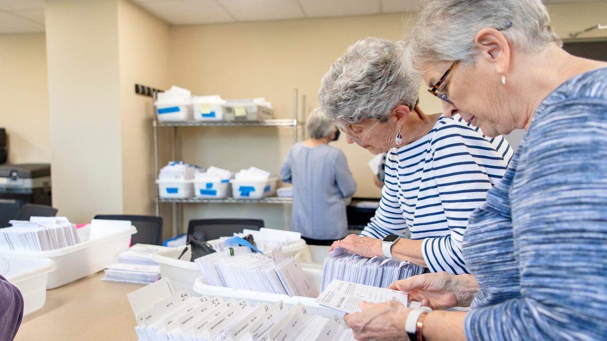 Volunteers sort through mail ballots in Centre County in this 2023 file photo. See how you can vote by mail this year and make sure your ballot gets counted.