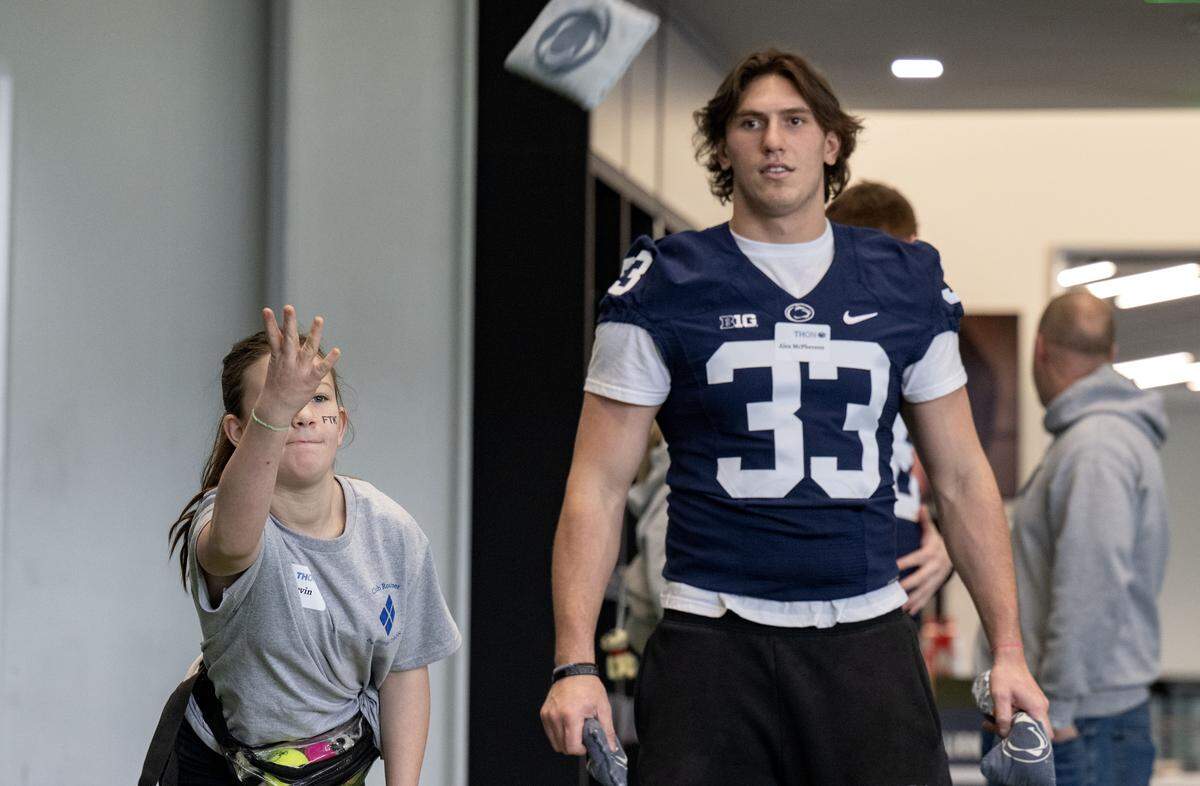 Devin Pulaski, 13, takes her turn in a game of cornhole with Penn State football player Alex McPherson during the Thon Explorers event at the Lasch Building on Saturday, Feb. 21, 2026.  