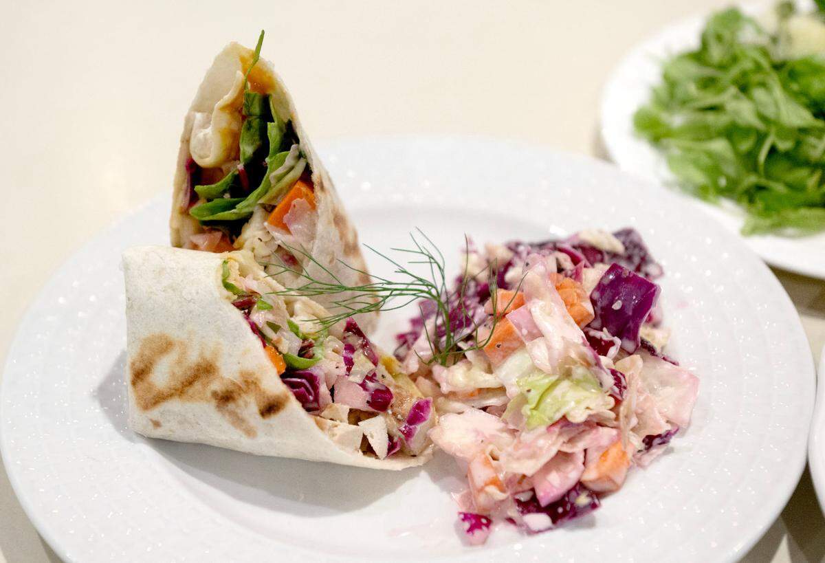 Brave New World wrap from Websters Bookstore Cafe on Wednesday, July 17, 2024. The meal features BBQ tofu using Trifolia tofu, quick pickles and slaw in a wrap and a kale and cabbage slaw
