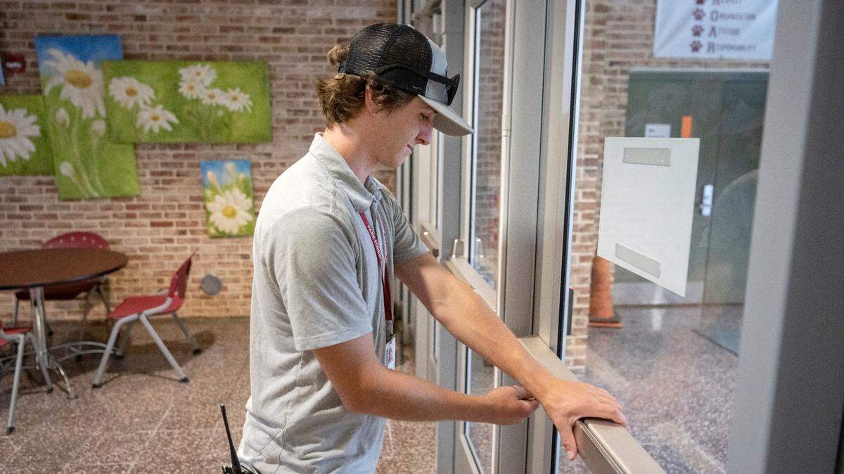 Gabe Cantolina, a custodian at Park Forest Middle School, locks the doors as the school day starts on Aug. 22. School districts across the county are struggling to fill support staff positions as the new school year begins.