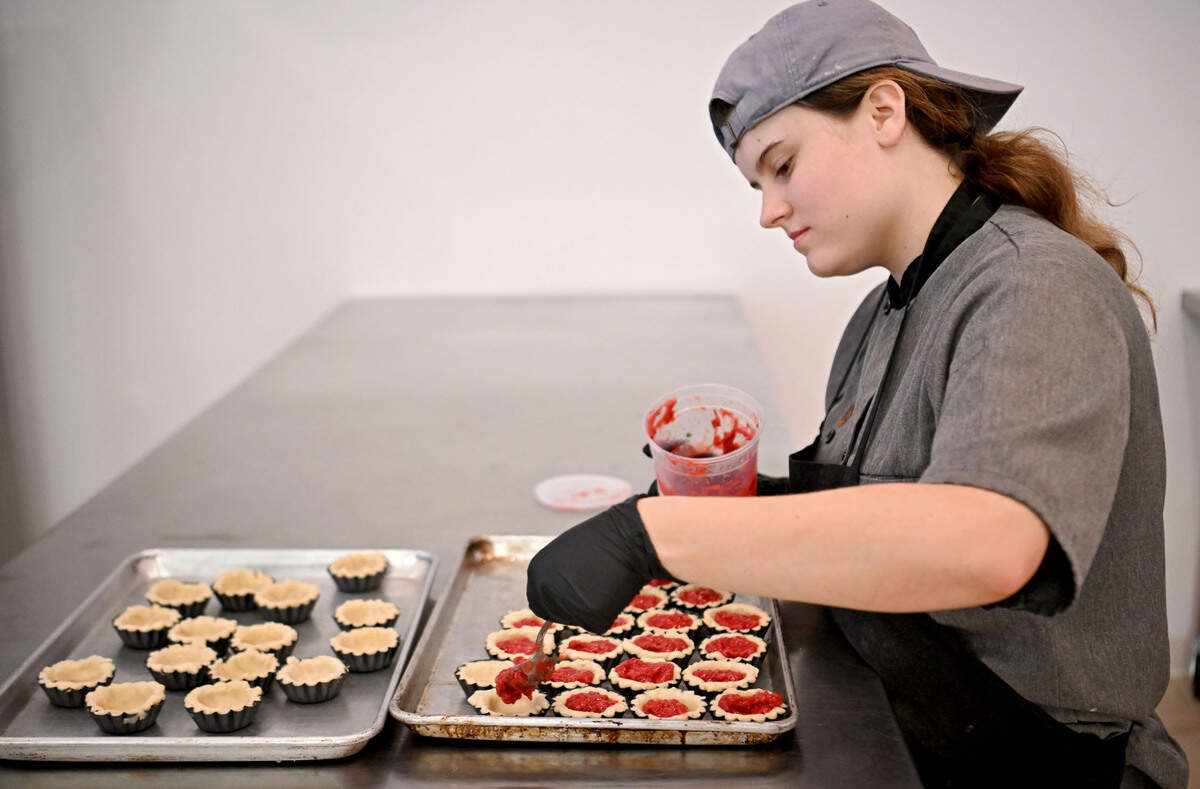 Lily Clickner fills a batch of raspberry tarts at Taproot Kitchen on Thursday, August 1, 2024.