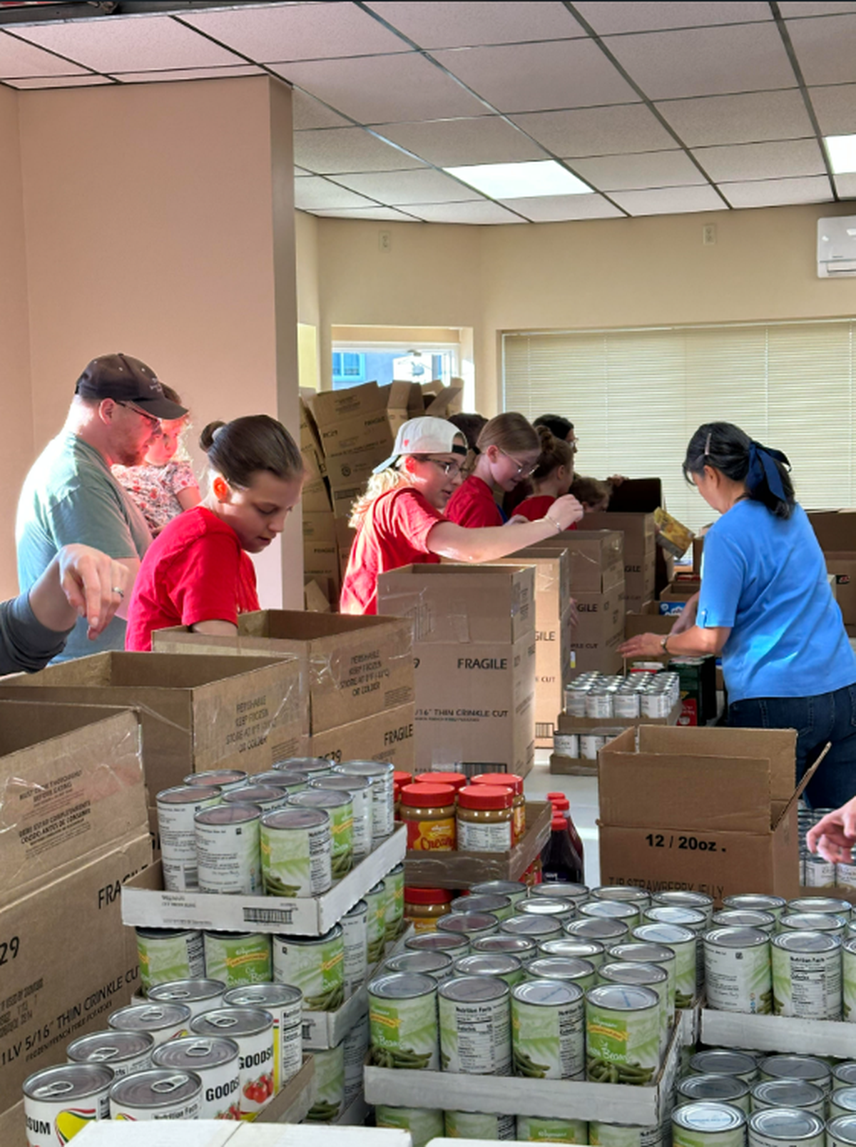 Volunteers pack food boxes at a packing session at CommonFood Centre County’s new packing center.