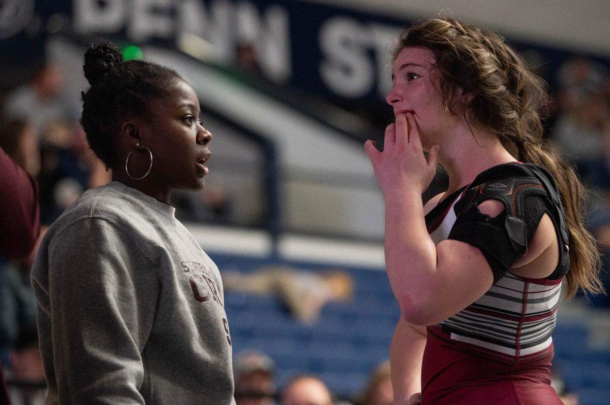 State High girls wrestling coach Eshia Willingham, left, comforts Isabelle Dubler, right, after a loss during a dual meet at Rec Hall on Tuesday, Dec. 17, 2024.