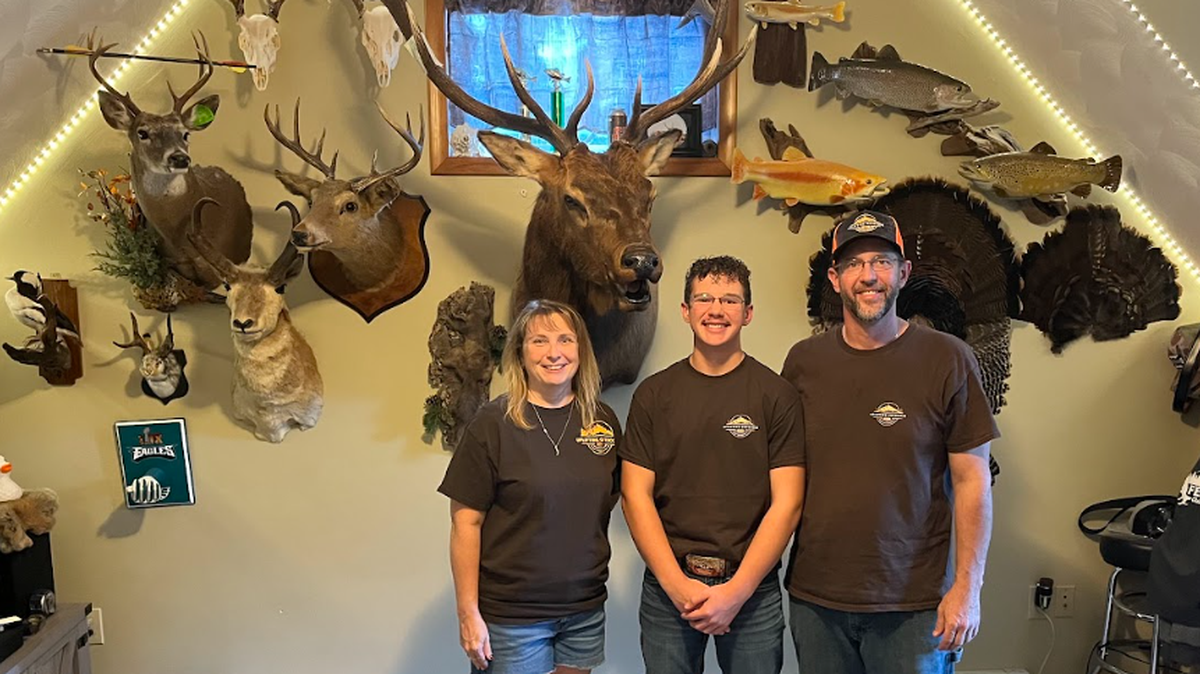 From left, Uplifting Outdoors President Karla Coudriet, founder CJ Coudriet and board member Tim Coudriet, standing in front of a wall of mounts. Karla and Tim Coudriet are also CJ Coudriet’s parents.