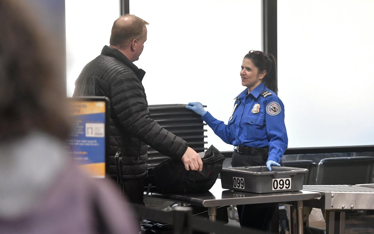 STSO Charlene Barrett chats with a passenger as he places his items to be scanned at the TSA checkpoint at the University Park Airport on Friday, Jan. 11, 2019.
