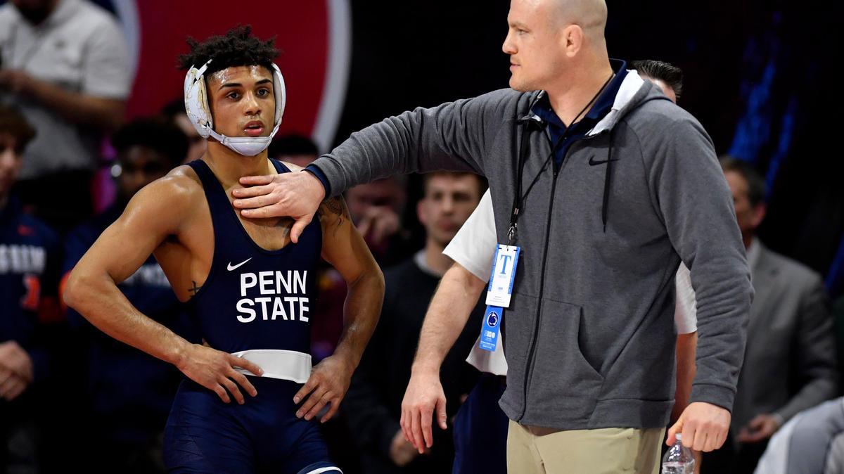Penn State wrestling coach Cael Sanderson pats Roman Bravo-Young on the chest as a call is reviewed during his bout against Iowa’s Austin DeSanto during the semi-finals of the Big Ten Wrestling championships at Rutgers on Saturday, March, 7, 2020.