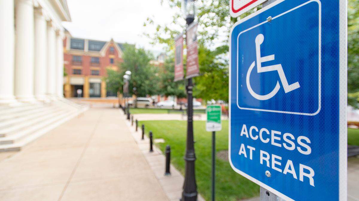A sign in front of the Centre County Courthouse tells those with disabilities to enter in the back.  Historic buildings are required to follow regulations by the Americans with Disabilities Act by providing alternate entrances.